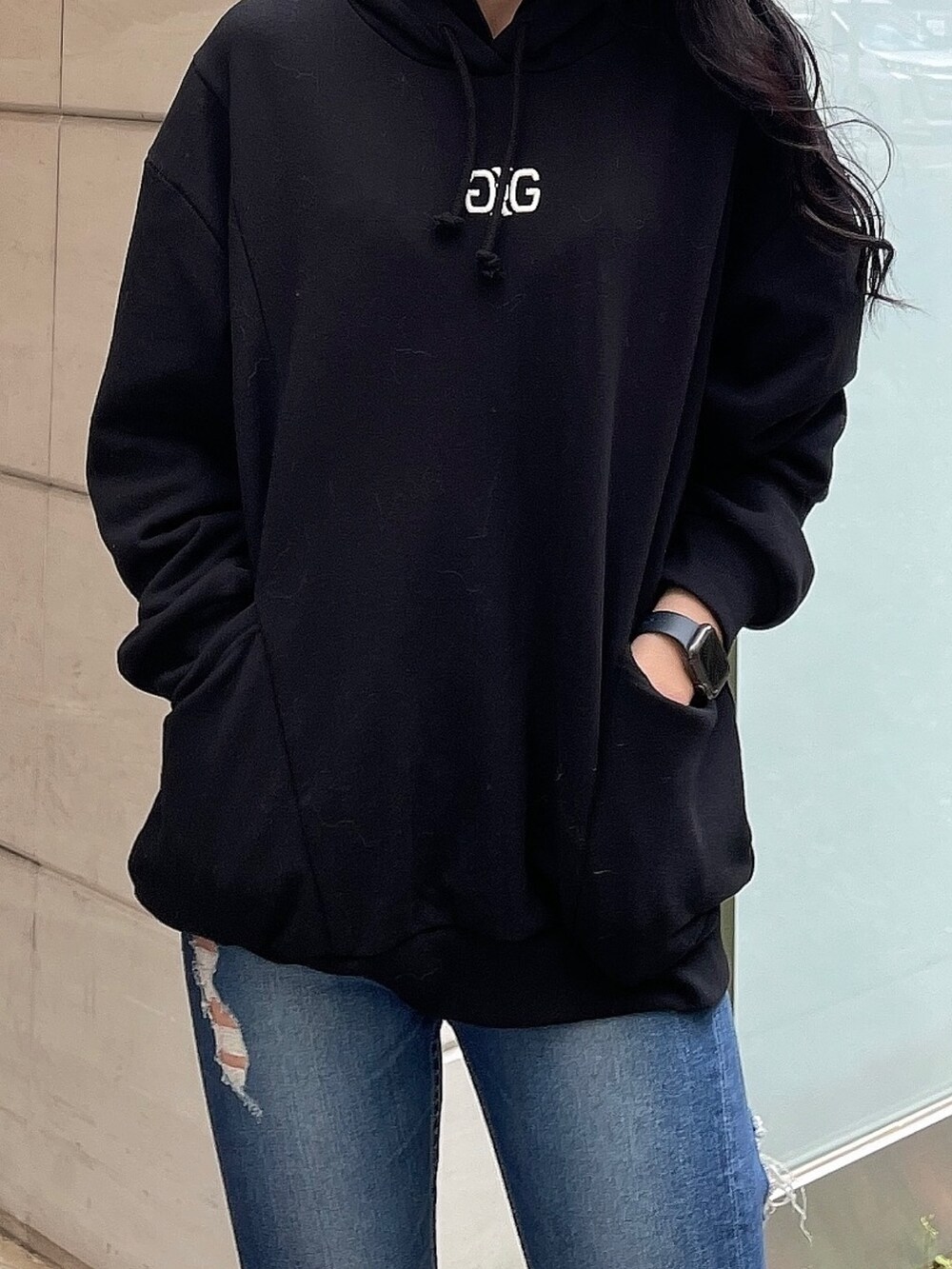 ブルー系のデニムパンツ、ブラック系のスウェット、ブラック系のパンプスを着用したレディースの冬コーディネートの8枚目の写真