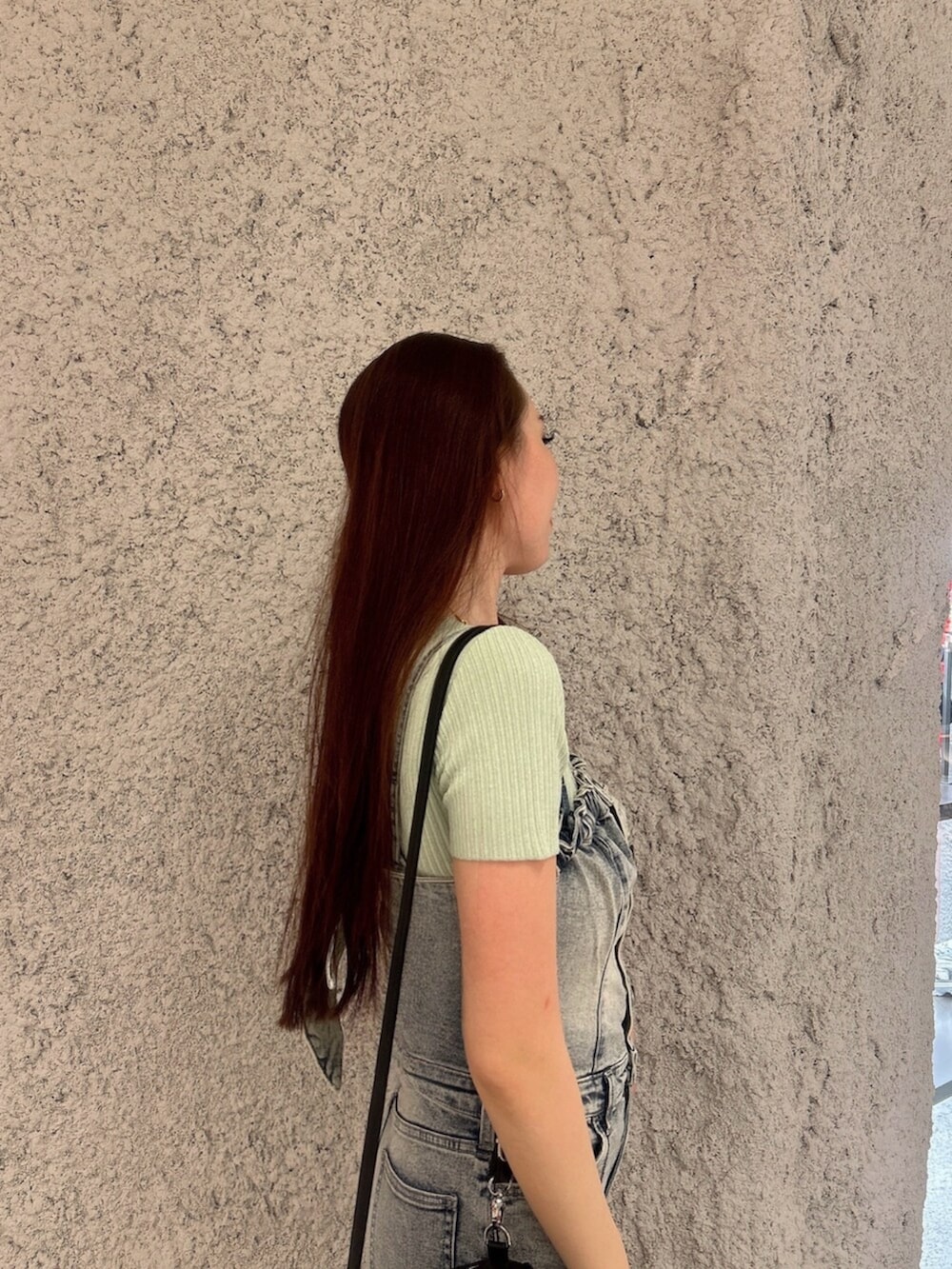 グリーン系のニット/セーター、ブルー系のつなぎ/オールインワン、ブラック系のバックパック/リュックを着用したレディースの春コーディネートの5枚目の写真