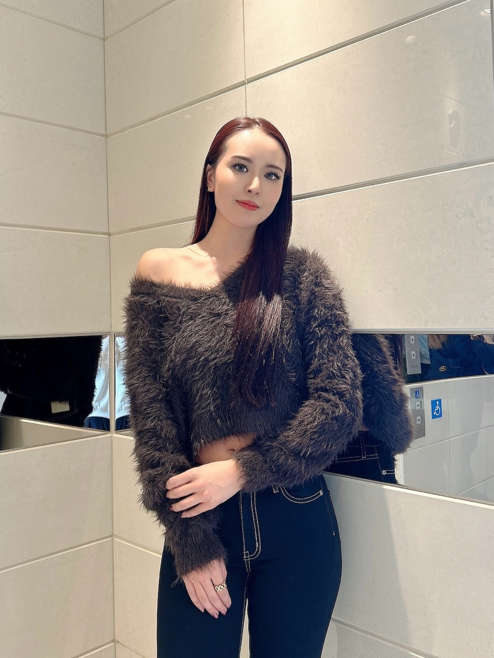 グレー系のニット/セーター、ブラック系のデニムパンツ、ブラック系のブーツを着用したレディースの冬コーディネートの4枚目の写真