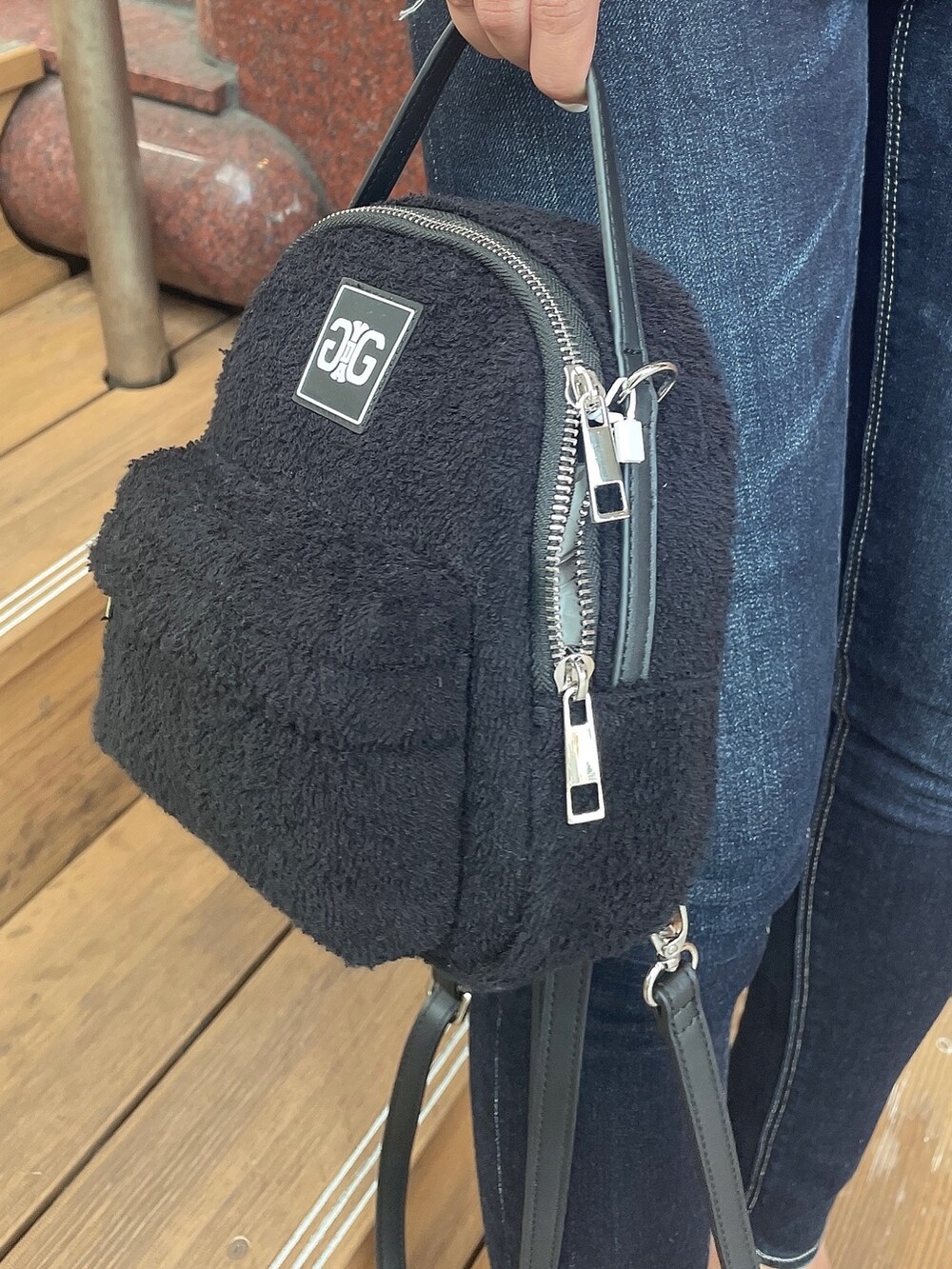 ホワイト系のタンクトップ、ブルー系のデニムパンツ、ブラック系のバックパック/リュックを着用したレディースの夏コーディネートの7枚目の写真