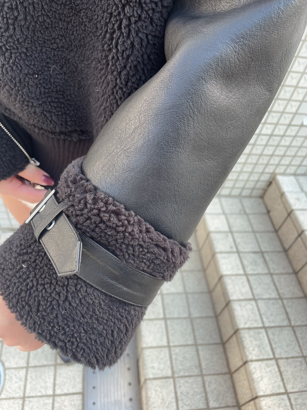 ブラック系のブルゾン、ホワイト系のワンピース、ブラック系のブーツを着用したレディースの冬コーディネートの6枚目の写真