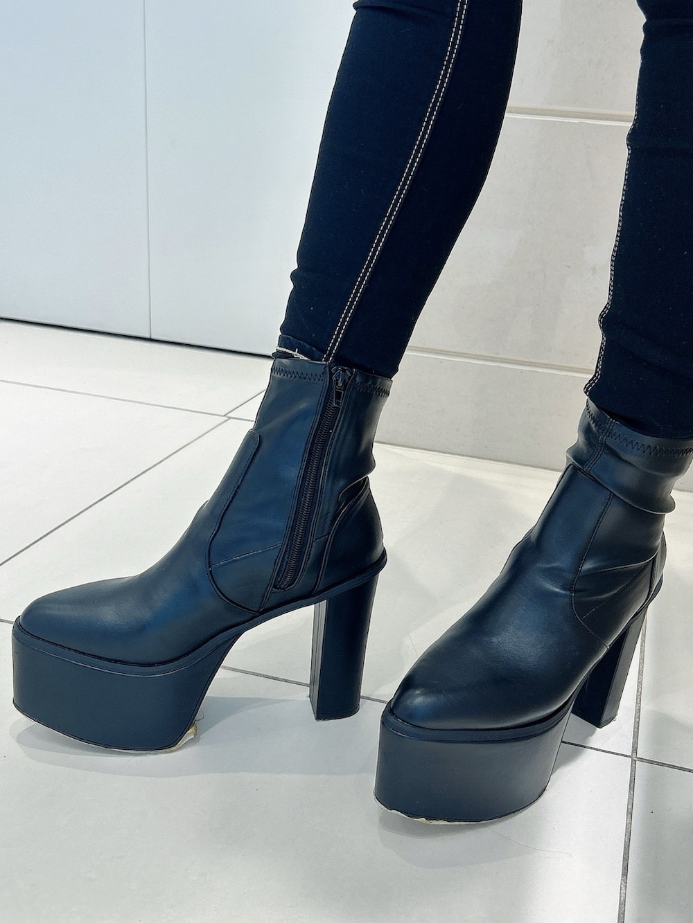 グレー系のニット/セーター、ブラック系のデニムパンツ、ブラック系のブーツを着用したレディースの冬コーディネートの8枚目の写真