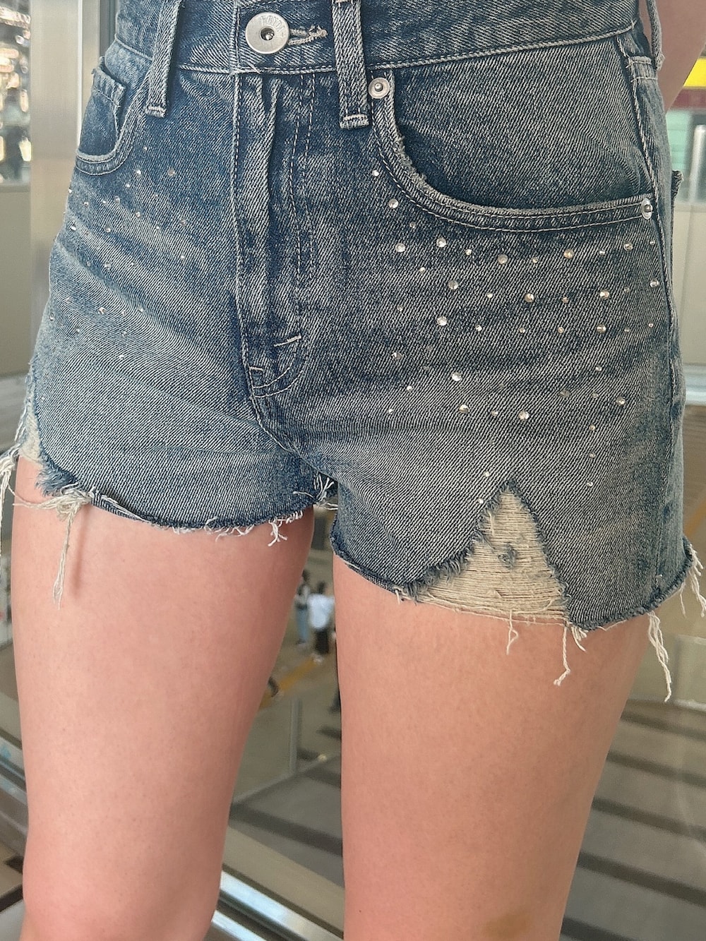 ベージュ系のTシャツ/カットソー、ブルー系のデニムパンツ、ベージュ系のサンダルを着用したレディースの夏コーディネートの7枚目の写真