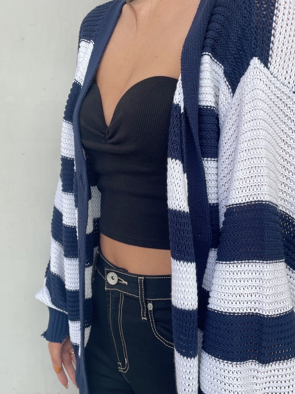 ブラック系のタンクトップ、ブルー系のデニムパンツ、ブラック系のパンプスを着用したレディースの夏コーディネートの5枚目の写真