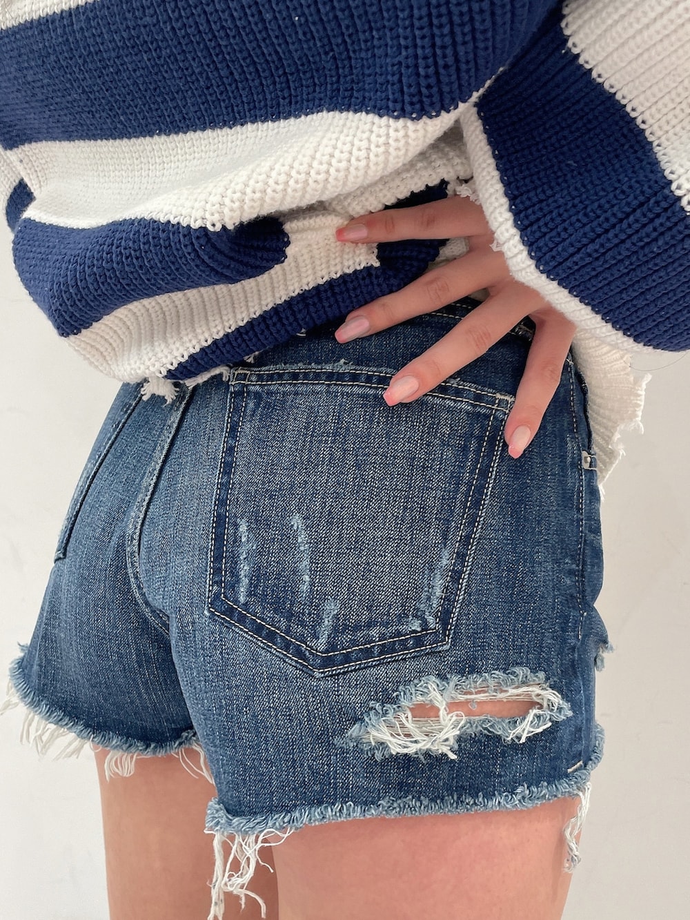 ブルー系のデニムパンツ、ブルー系のカーディガン/ボレロ、ブラック系のキャミソールを着用したレディースの春コーディネートの9枚目の写真