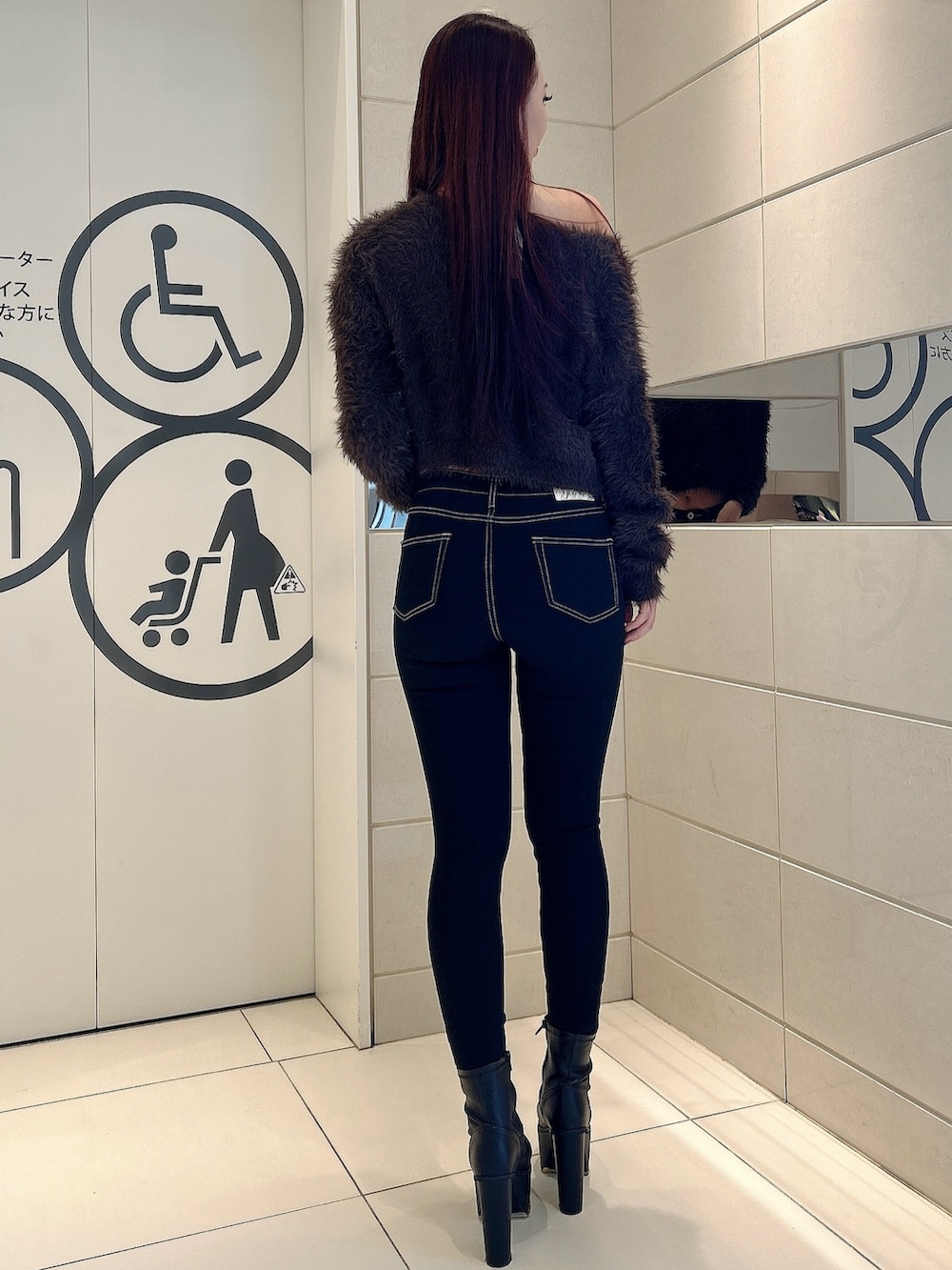 グレー系のニット/セーター、ブラック系のデニムパンツ、ブラック系のブーツを着用したレディースの冬コーディネートの3枚目の写真