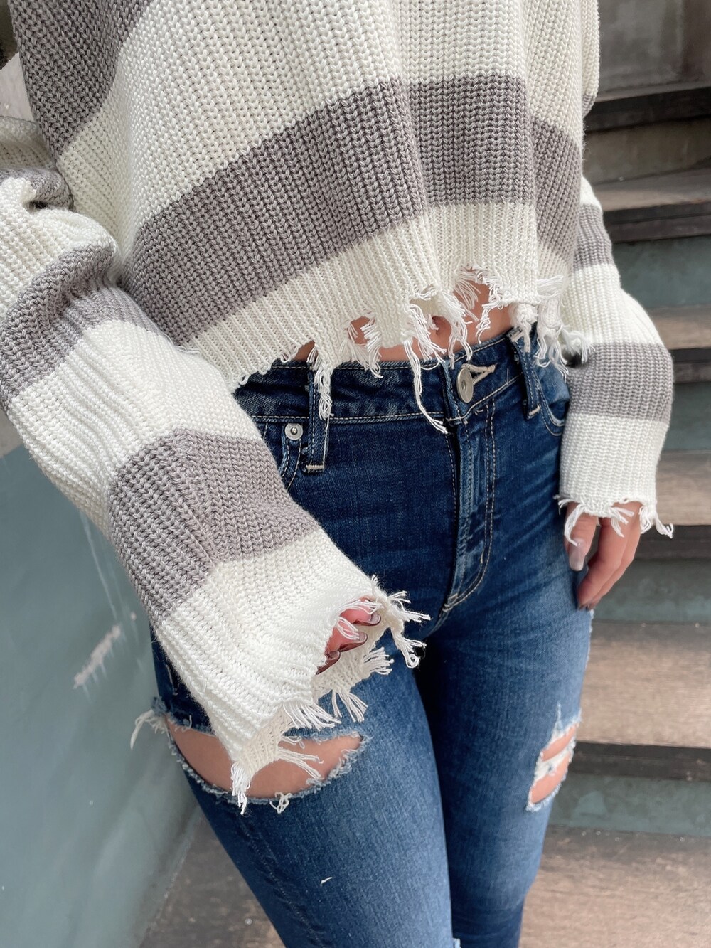 ブルー系のデニムパンツ、ブラック系のパンプス、グレー系のニット/セーターを着用したレディースの冬コーディネートの5枚目の写真