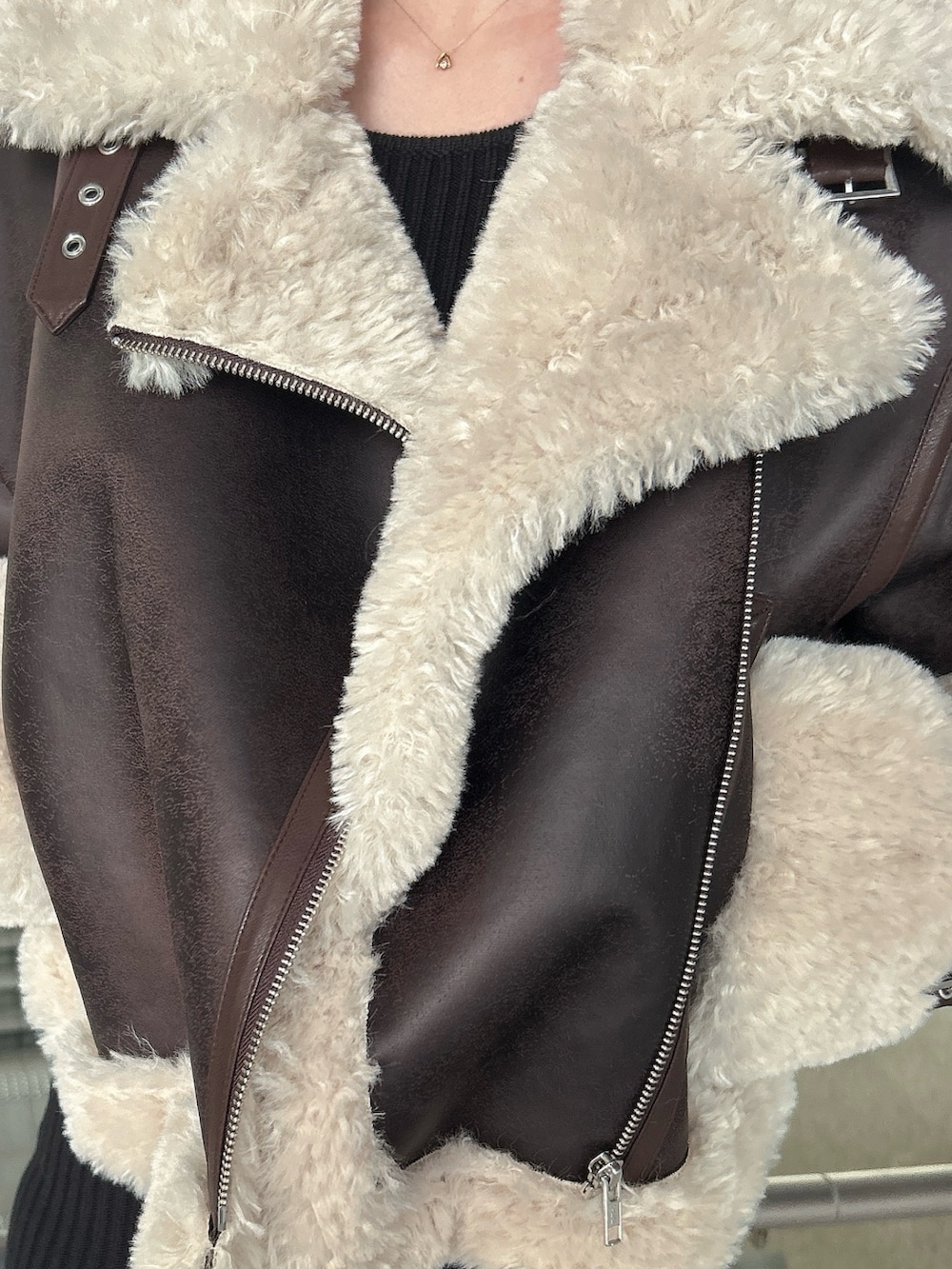 ブラウン系のムートンコート、ブラック系のブーツを着用したレディースの秋コーディネートの7枚目の写真