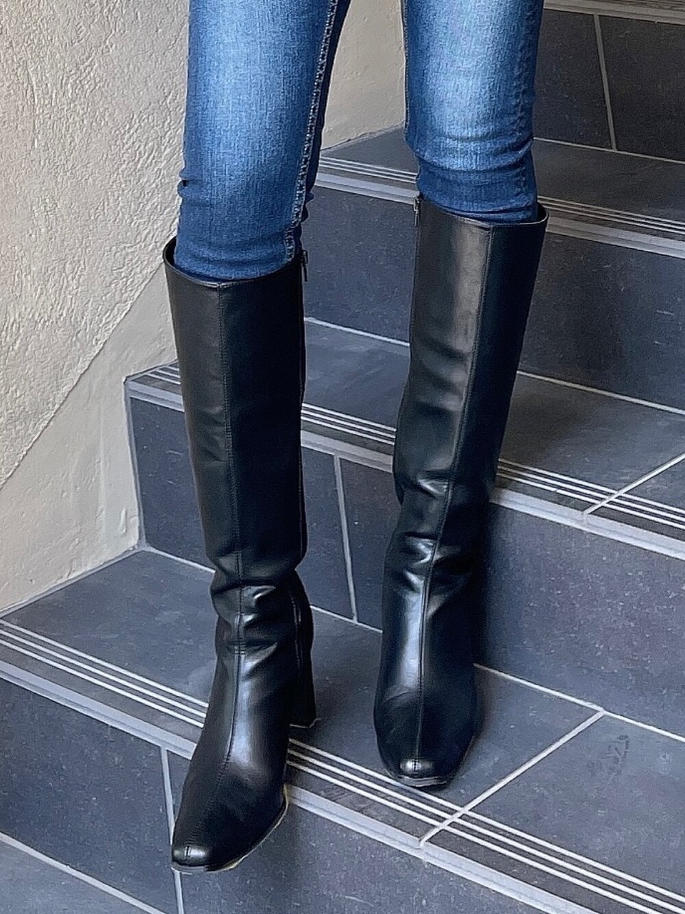 ベージュ系のニット/セーター、ブルー系のデニムパンツ、ブラック系のブーツを着用したレディースの秋コーディネートの7枚目の写真