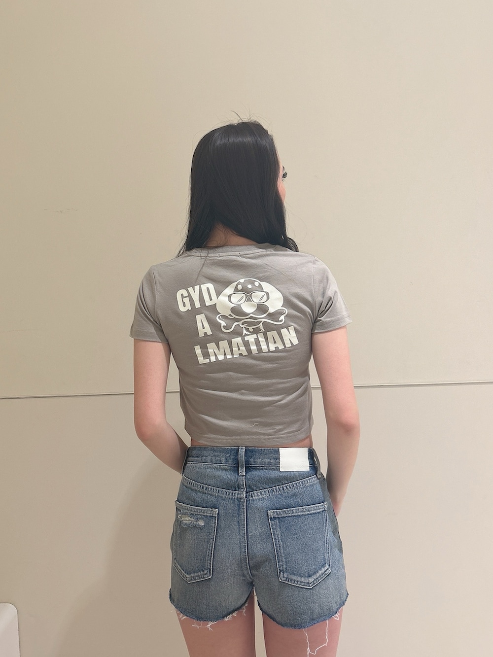 ベージュ系のTシャツ/カットソー、ブルー系のデニムパンツ、ベージュ系のサンダルを着用したレディースの夏コーディネートの5枚目の写真