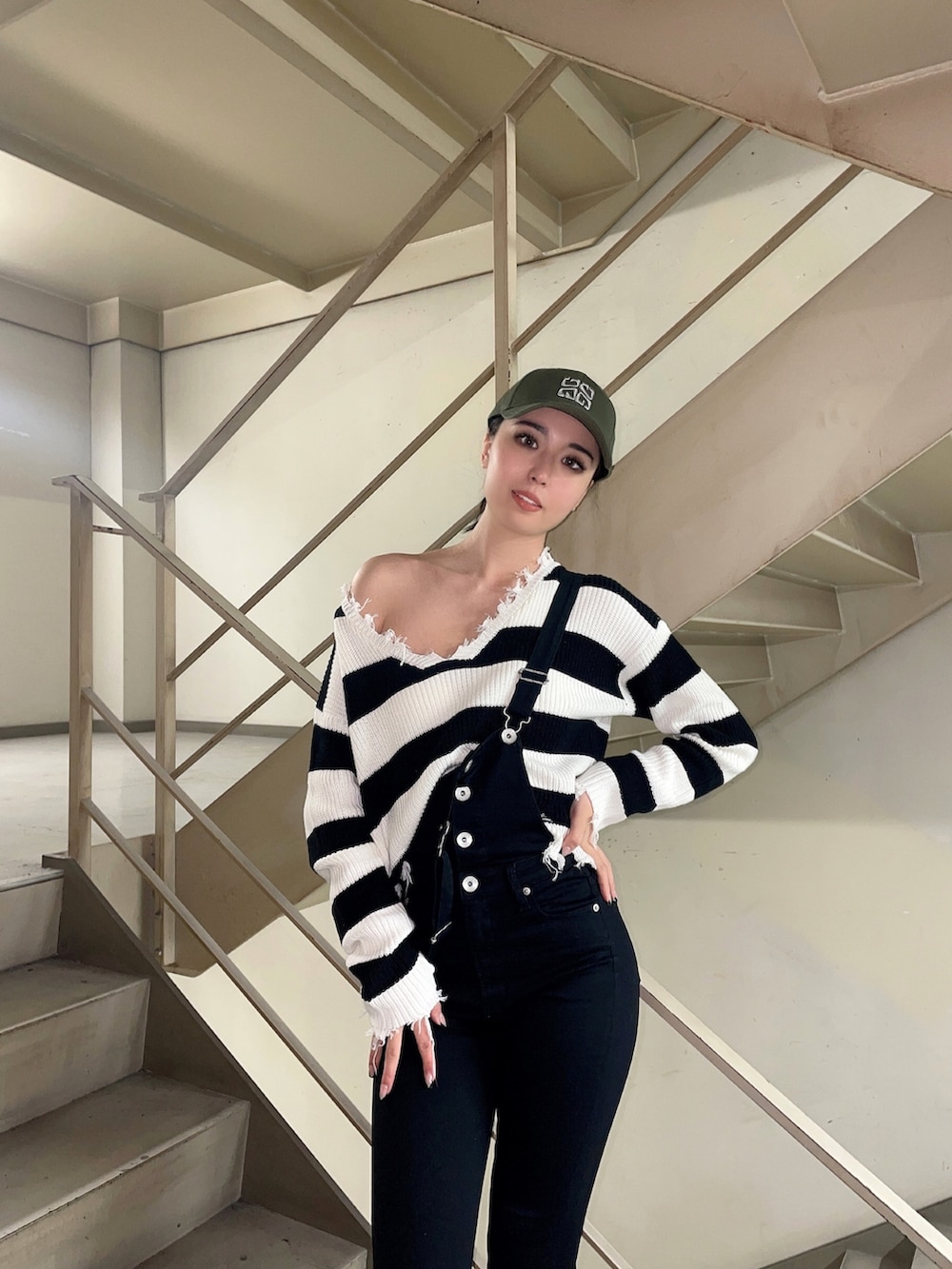 ブラック系のニット/セーター、ブラック系のサロペット/オーバーオール、ブラック系のパンプスを着用したレディースの冬コーディネートの3枚目の写真