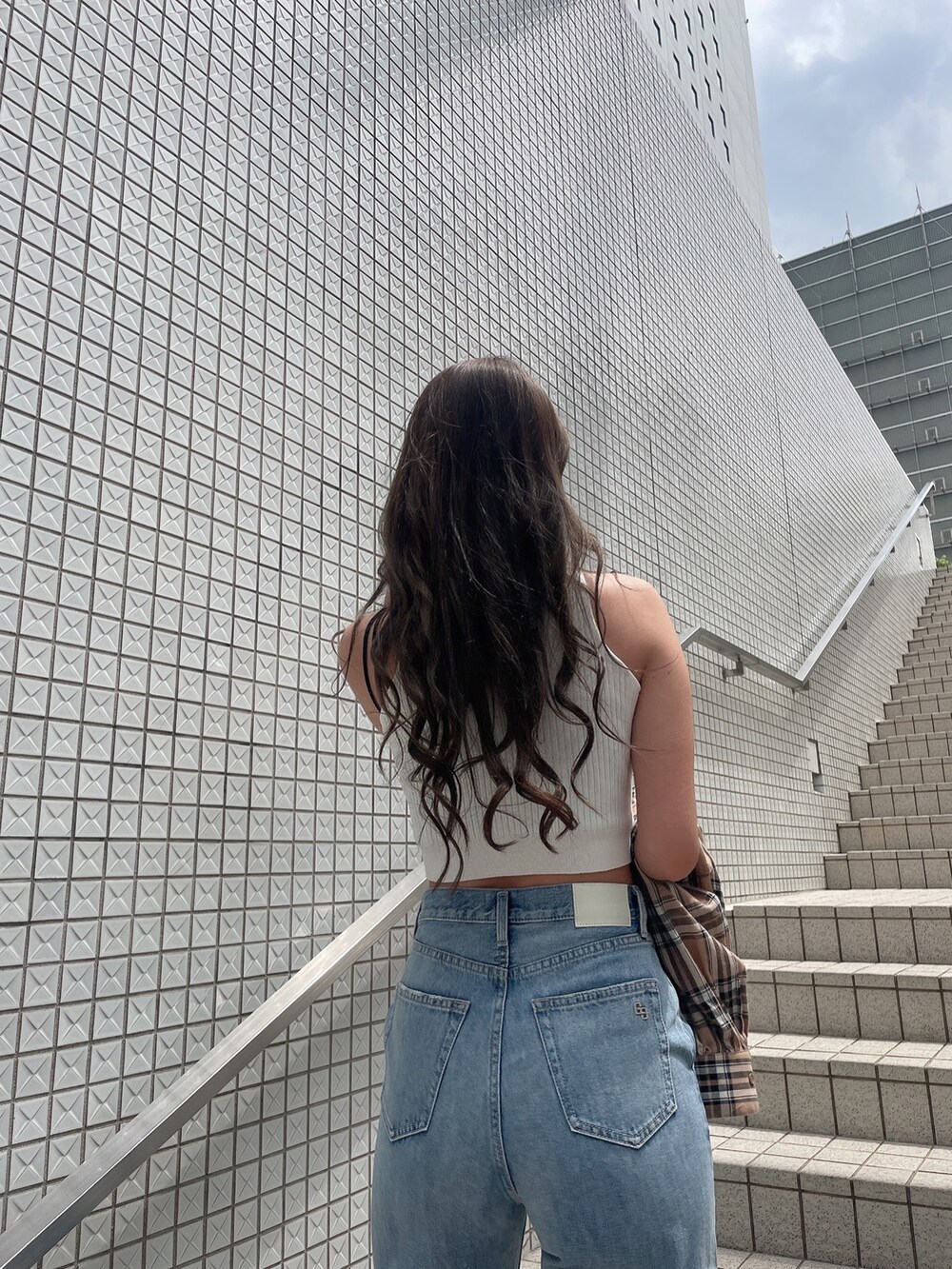 ベージュ系のシャツ/ブラウス、ホワイト系のタンクトップ、ブルー系のデニムパンツを着用したレディースの春コーディネートの5枚目の写真