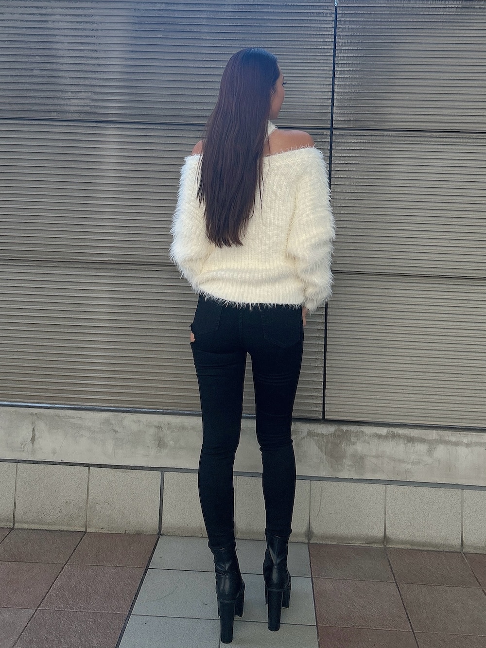 ホワイト系のニット/セーター、ブラック系のデニムパンツ、ブラック系のブーツを着用したレディースの秋コーディネートの3枚目の写真