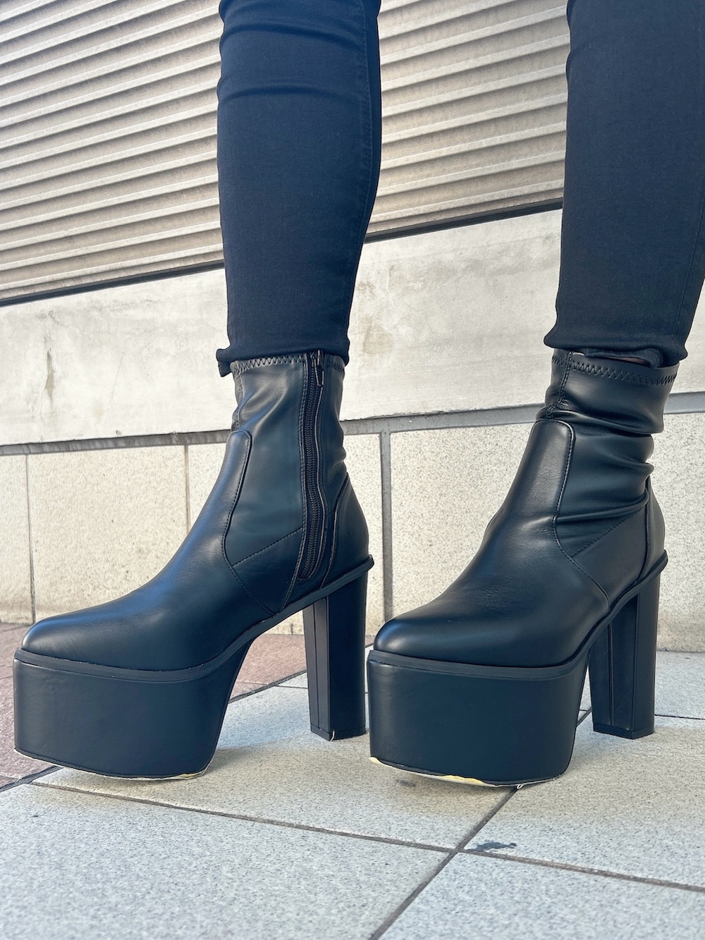 ホワイト系のニット/セーター、ブラック系のデニムパンツ、ブラック系のブーツを着用したレディースの秋コーディネートの9枚目の写真