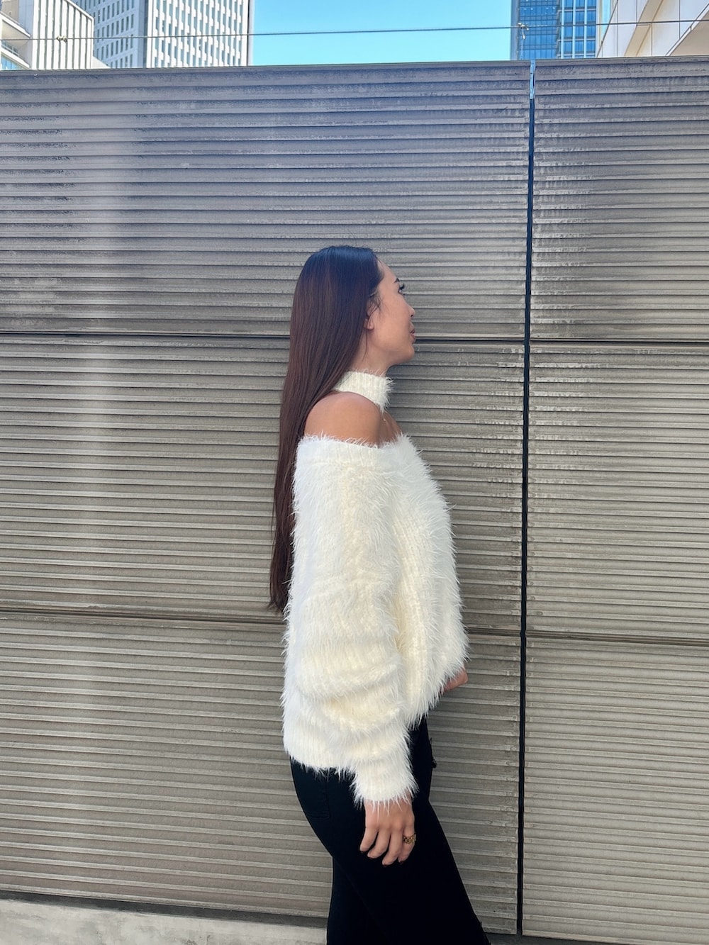 ホワイト系のニット/セーター、ブラック系のデニムパンツ、ブラック系のブーツを着用したレディースの秋コーディネートの6枚目の写真