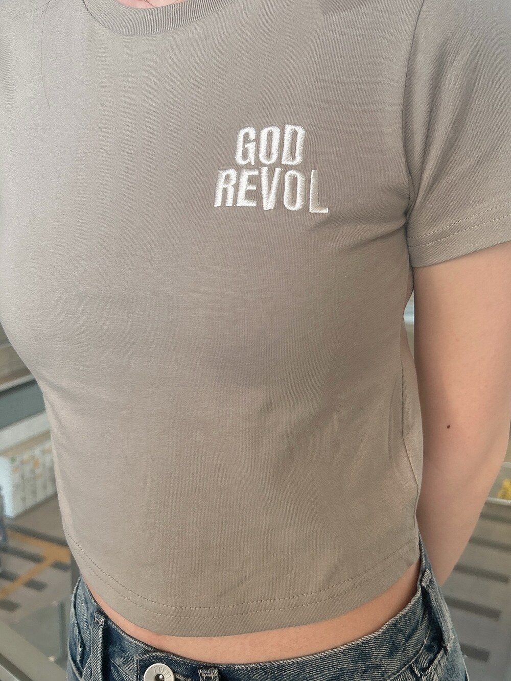 ベージュ系のTシャツ/カットソー、ブルー系のデニムパンツ、ベージュ系のサンダルを着用したレディースの夏コーディネートの6枚目の写真