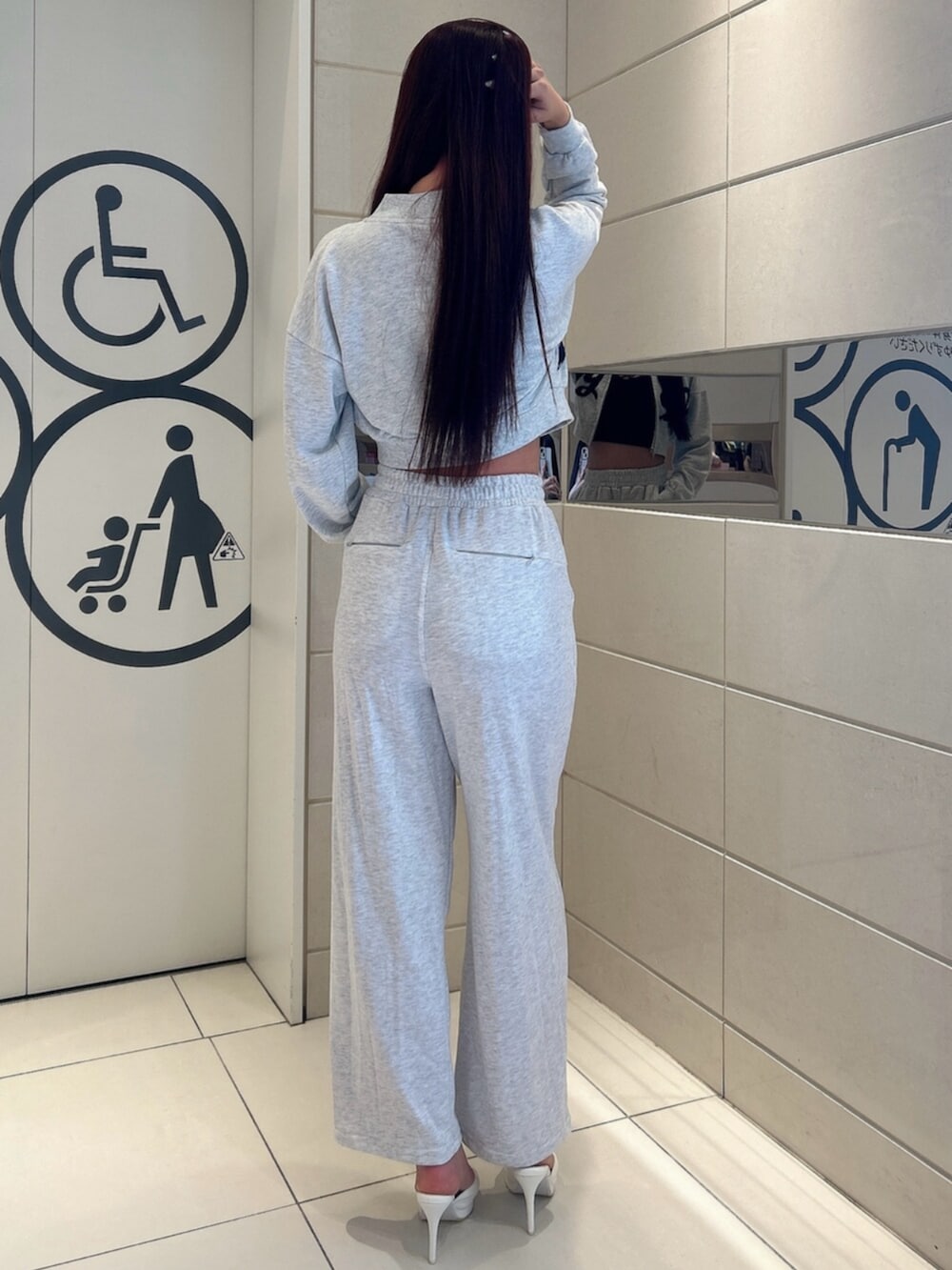 ホワイト系のパンプス、グレー系のスウェット、グレー系のスウェットパンツを着用したレディースの冬コーディネートの3枚目の写真