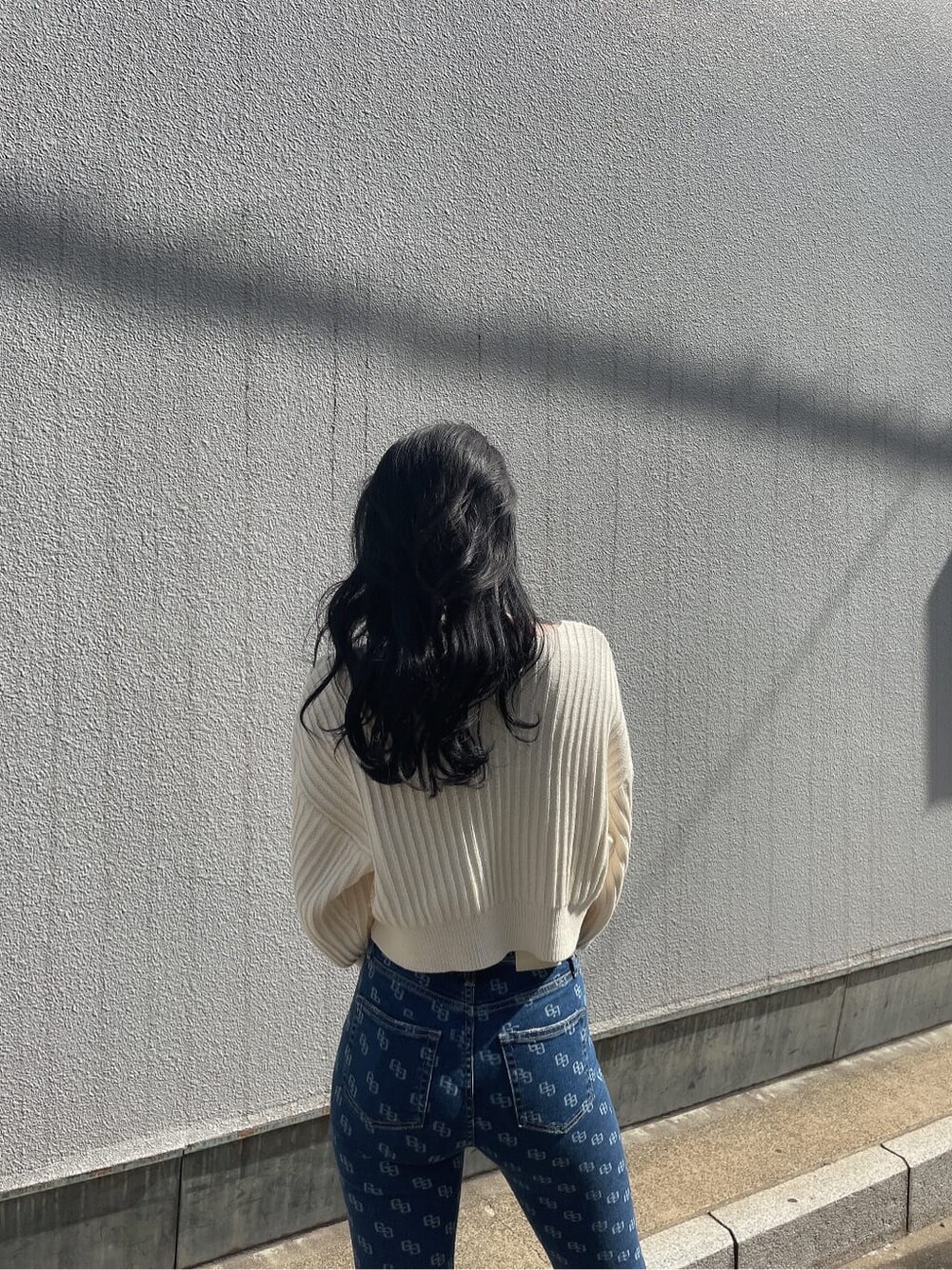 ホワイト系のパンプス、ブルー系のデニムパンツ、ホワイト系のニット/セーターを着用したレディースの春コーディネートの3枚目の写真