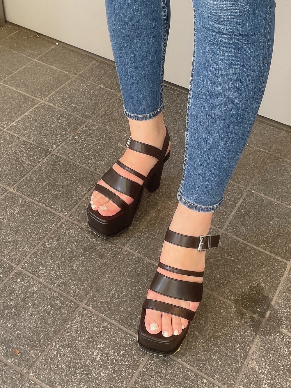 ブラック系のTシャツ/カットソー、ブルー系のデニムパンツ、ブラック系のサンダルを着用したレディースの春コーディネートの8枚目の写真