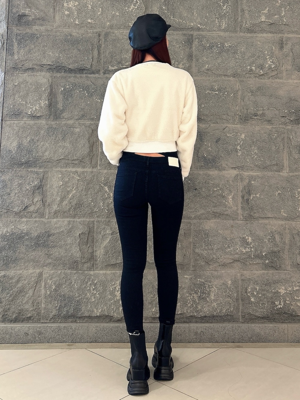 ホワイト系のTシャツ/カットソー、ブラック系のデニムパンツ、ブラック系のブーツを着用したレディースの秋コーディネートの4枚目の写真