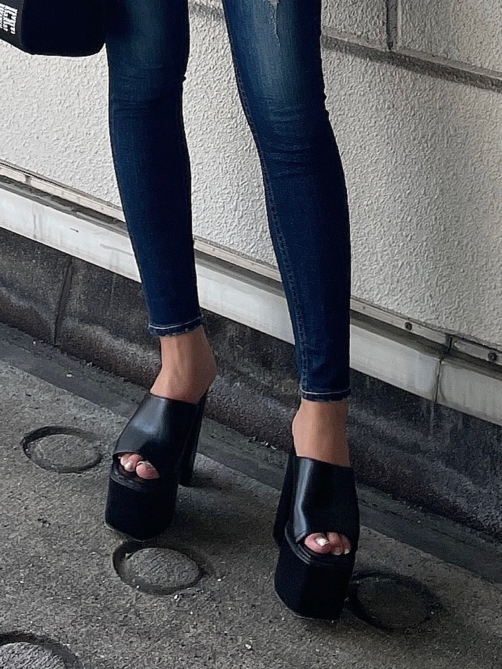グレー系のパーカー、ブルー系のデニムパンツ、ブラック系のハンドバッグを着用したレディースの夏コーディネートの7枚目の写真