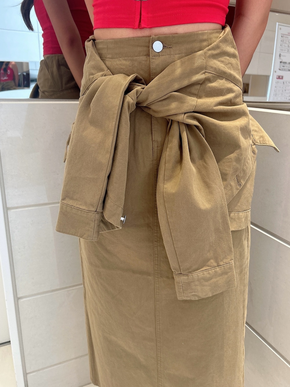 レッド系のキャミソール、グリーン系のスカート、ホワイト系のサンダルを着用したレディースの夏コーディネートの7枚目の写真