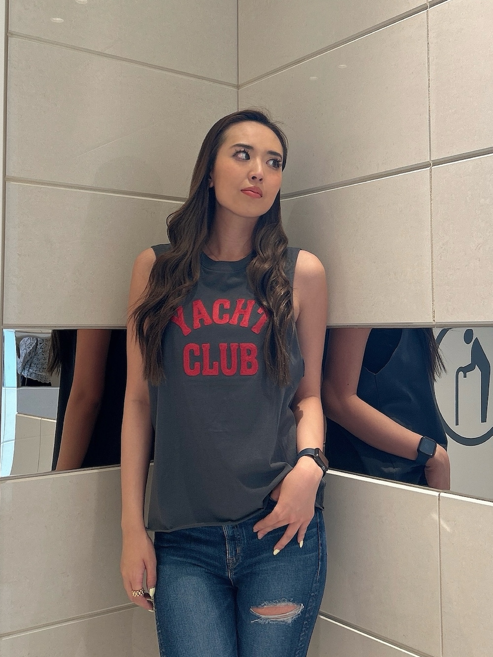 グレー系のタンクトップ、ブルー系のデニムパンツ、ベージュ系のサンダルを着用したレディースの夏コーディネートの5枚目の写真