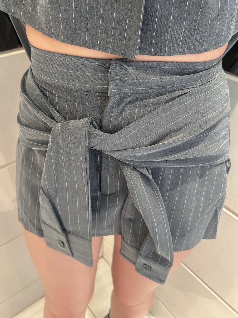 グレー系のテーラードジャケット、グレー系のスカート、ブラック系のバックパック/リュックを着用したレディースの秋コーディネートの6枚目の写真