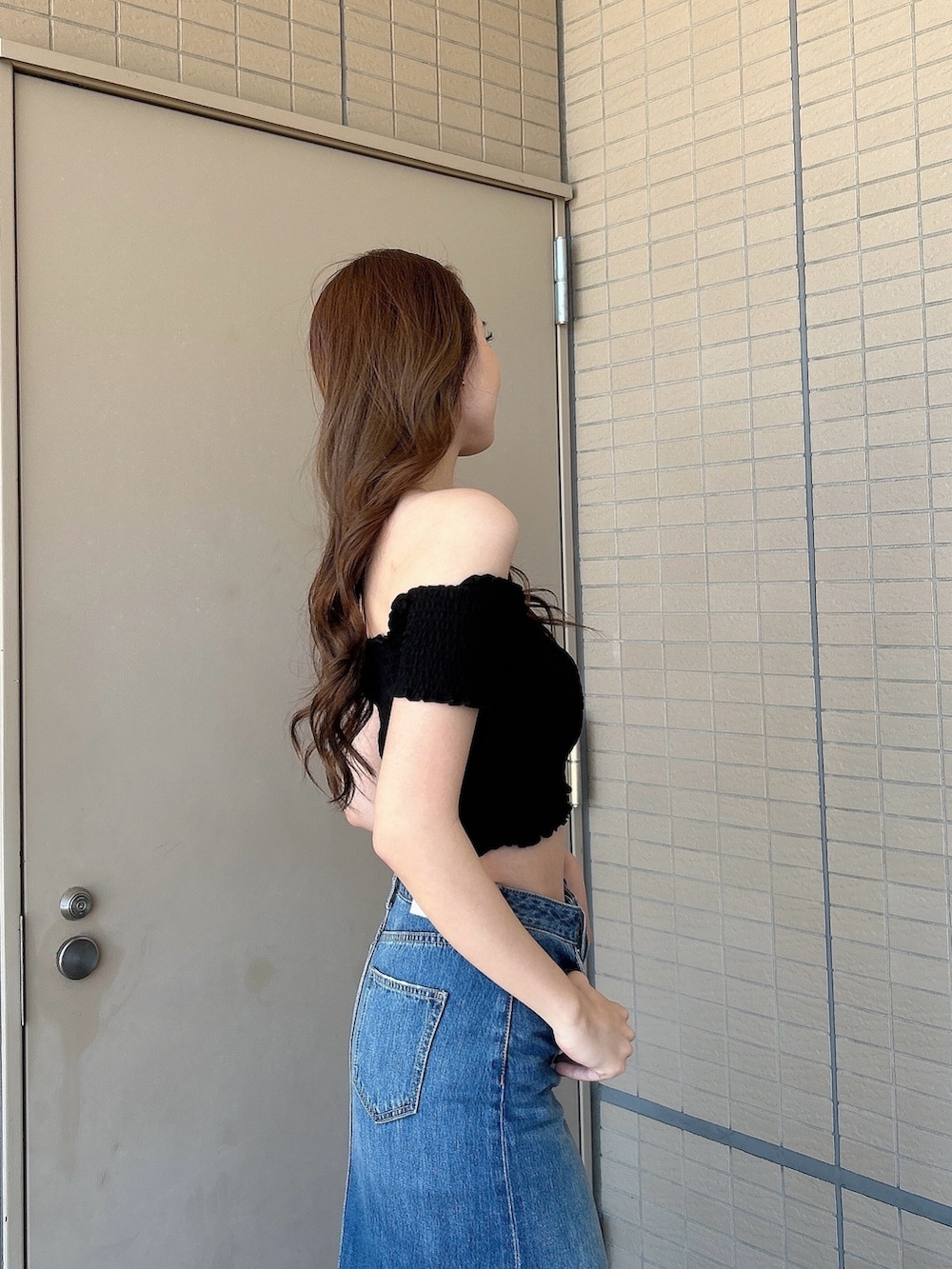 ブラック系のサンダル、ブルー系のデニムスカート、ブラック系のTシャツ/カットソーを着用したレディースの夏コーディネートの5枚目の写真