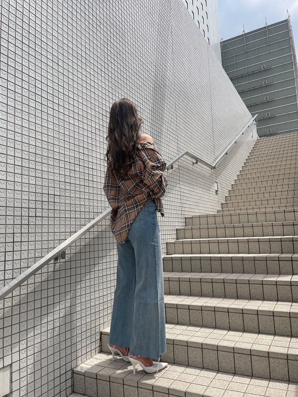 ベージュ系のシャツ/ブラウス、ホワイト系のタンクトップ、ブルー系のデニムパンツを着用したレディースの春コーディネートの2枚目の写真