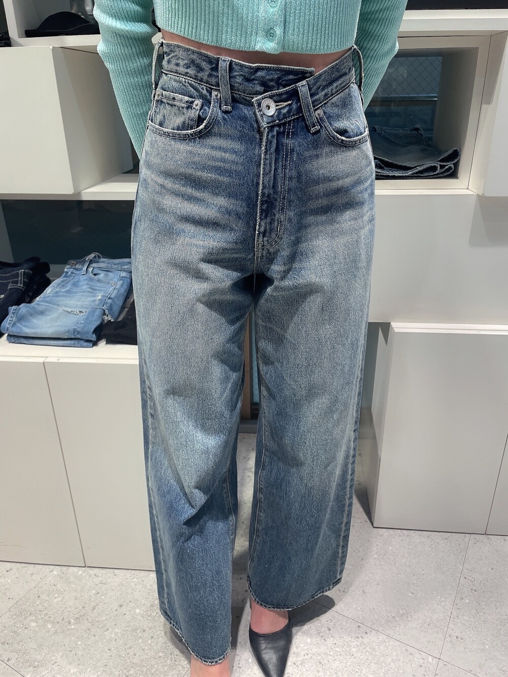 グリーン系のカーディガン/ボレロ、ブルー系のデニムパンツ、ブラック系のパンプスを着用したレディースの冬コーディネートの7枚目の写真