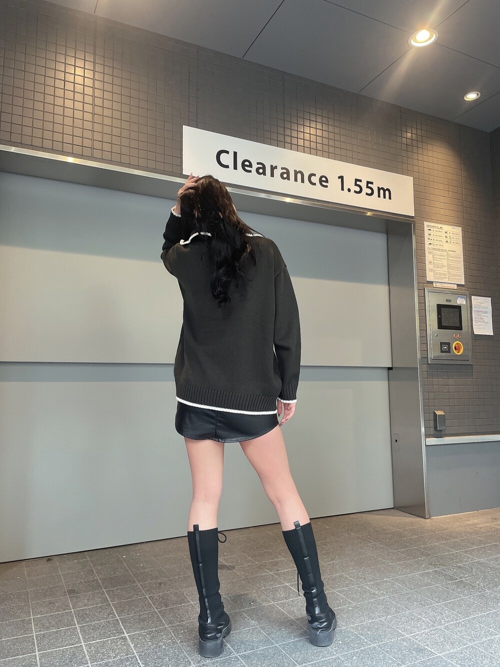 グレー系のニット/セーター、ブラック系のスカート、ブラック系のブーツを着用したレディースの冬コーディネートの4枚目の写真