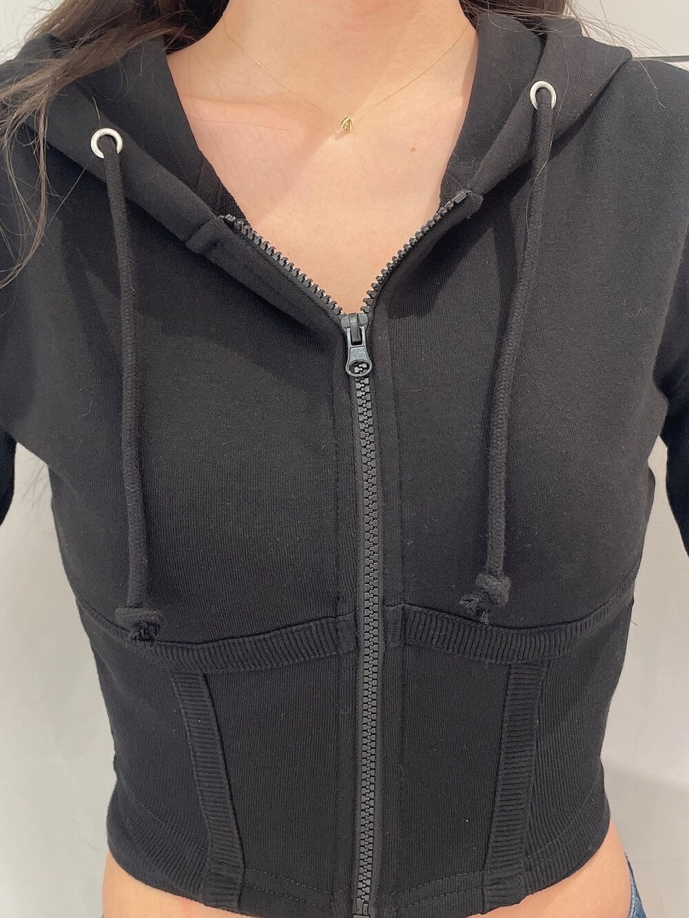 ブラック系のパーカー、ホワイト系のキャミソール、ブルー系のデニムパンツを着用したレディースの冬コーディネートの5枚目の写真