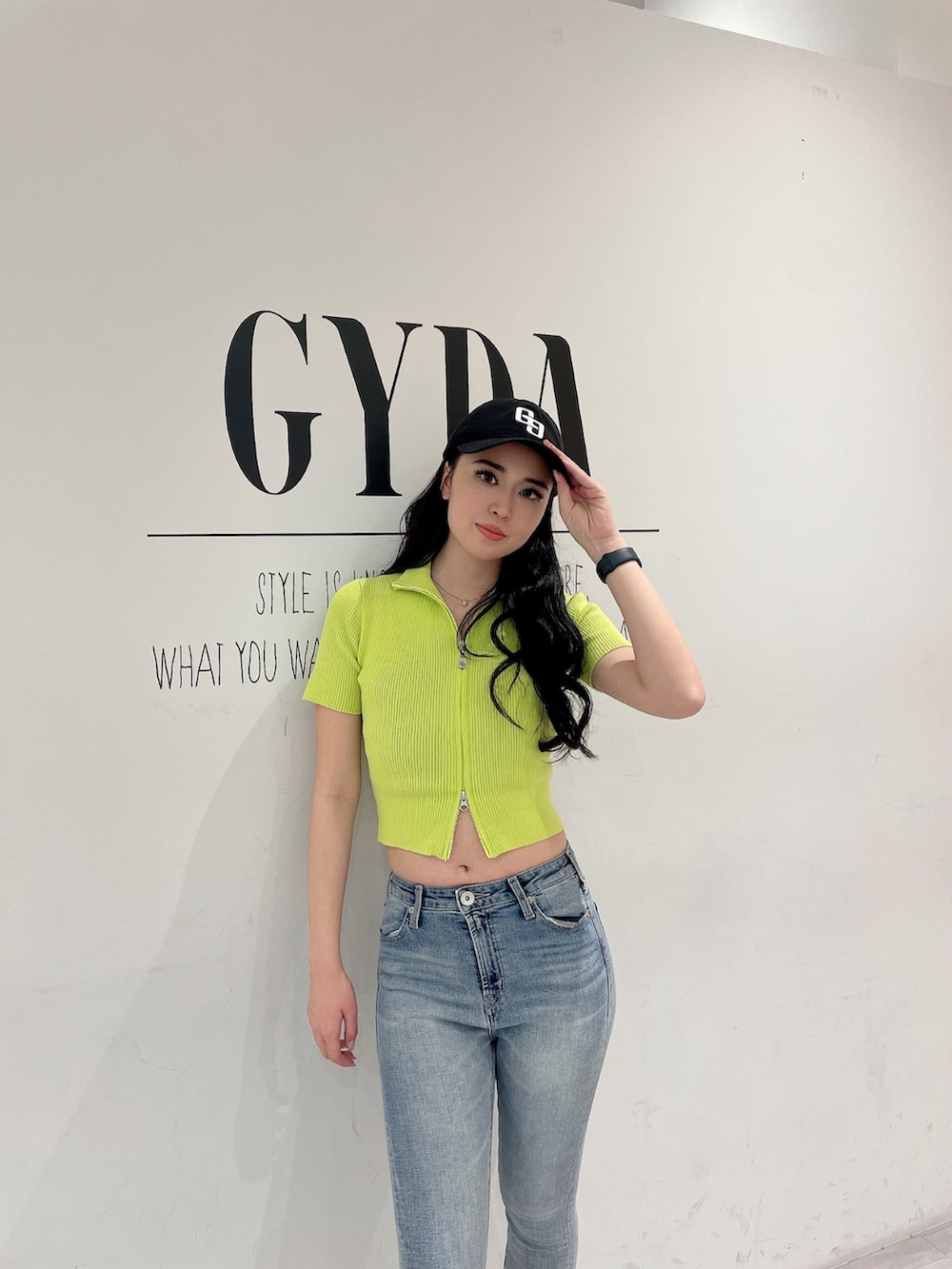 グリーン系のニット/セーター、ブルー系のデニムパンツ、ホワイト系のパンプスを着用したレディースの春コーディネートの3枚目の写真