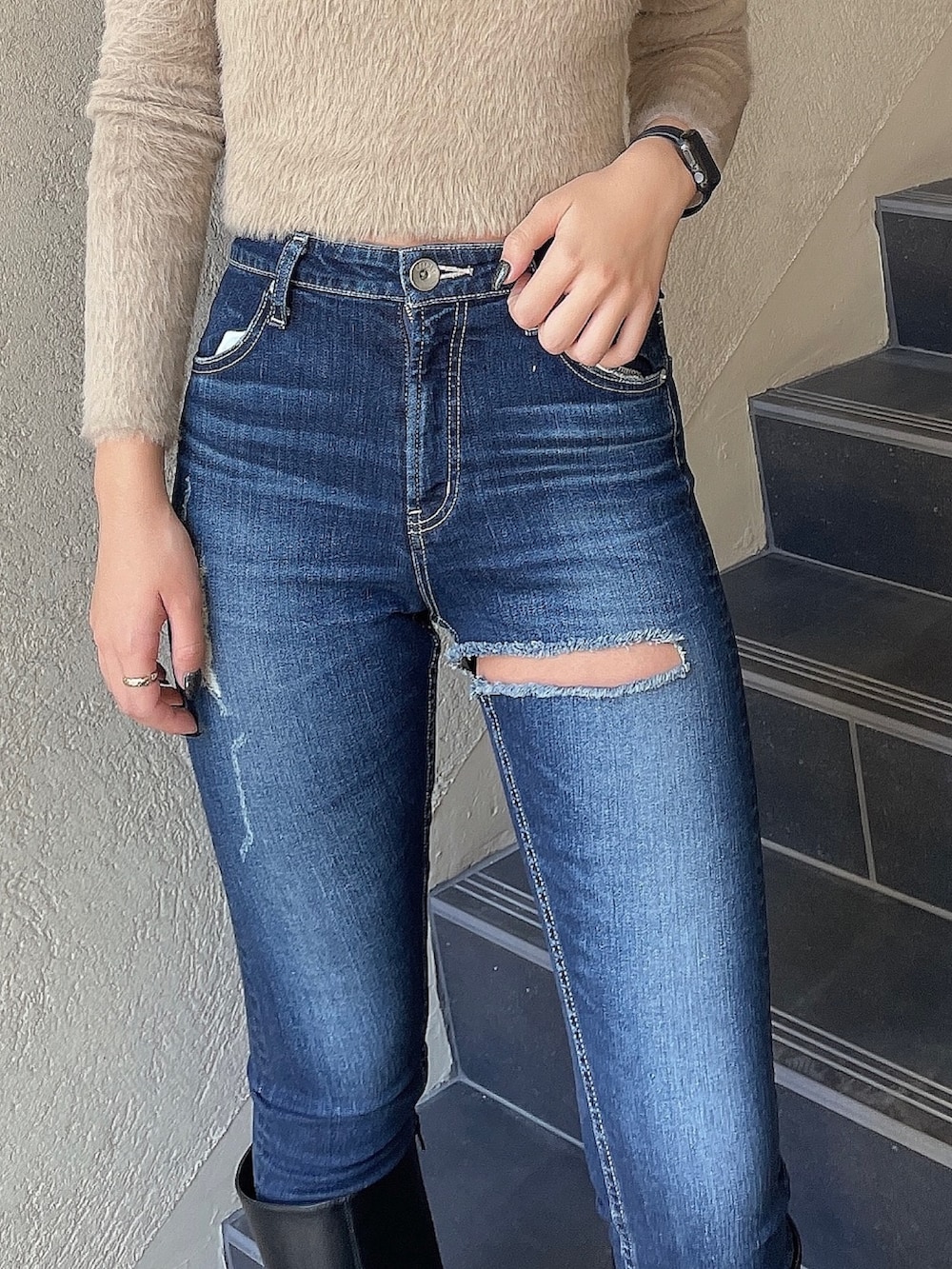 ベージュ系のニット/セーター、ブルー系のデニムパンツ、ブラック系のブーツを着用したレディースの秋コーディネートの4枚目の写真