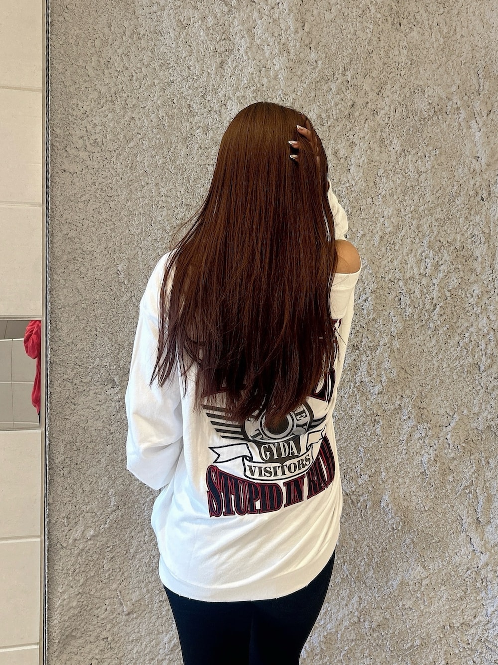 ホワイト系のスウェット、ブラック系のデニムパンツ、ブラック系のブーツを着用したレディースの秋コーディネートの6枚目の写真