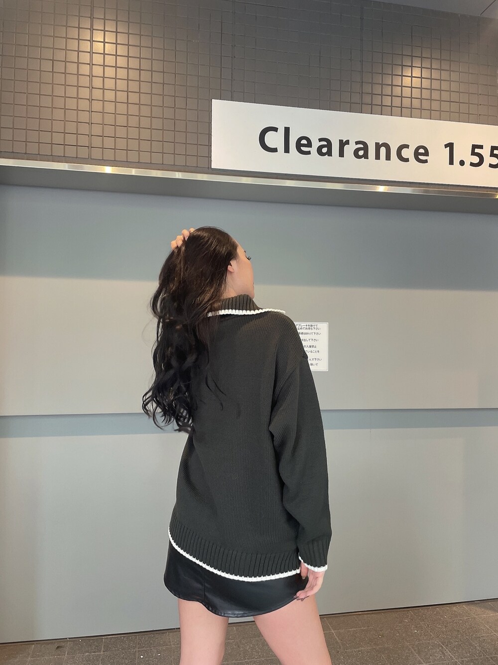 グレー系のニット/セーター、ブラック系のスカート、ブラック系のブーツを着用したレディースの冬コーディネートの3枚目の写真