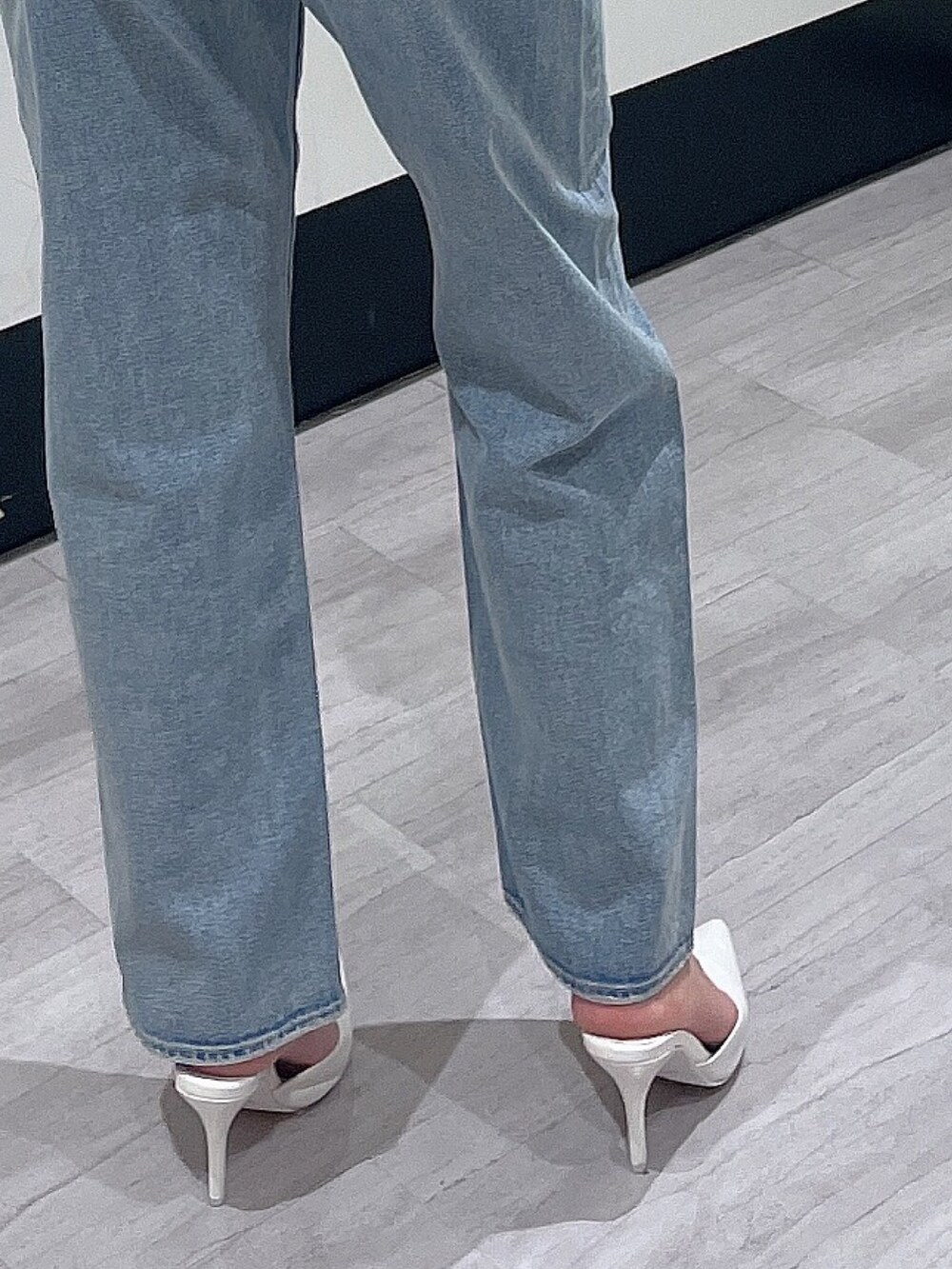 グリーン系のスウェット、ブルー系のデニムパンツ、ホワイト系のパンプスを着用したレディースの冬コーディネートの7枚目の写真