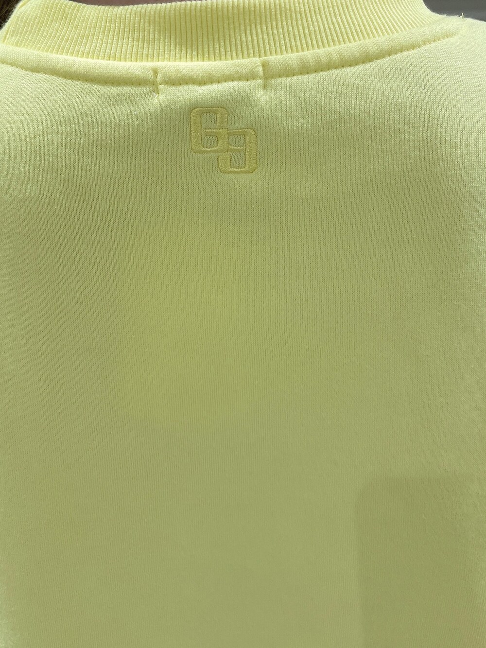 イエロー系のスウェット、ブラック系のブーツ、ブラック系のレギンス/スパッツを着用したレディースの秋コーディネートの6枚目の写真