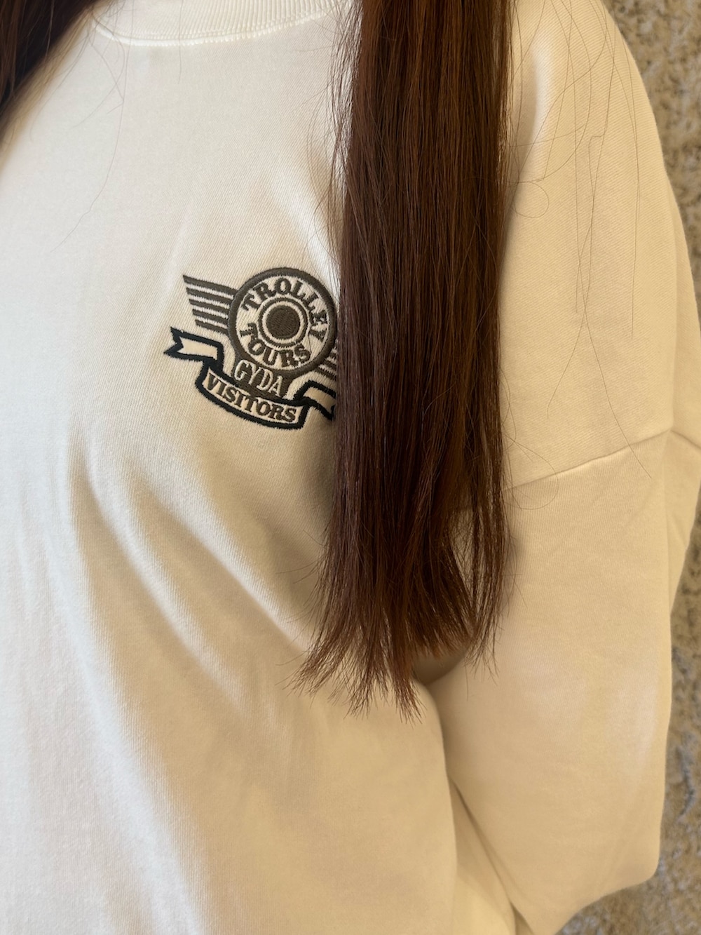 ホワイト系のスウェット、ブラック系のデニムパンツ、ブラック系のブーツを着用したレディースの秋コーディネートの7枚目の写真