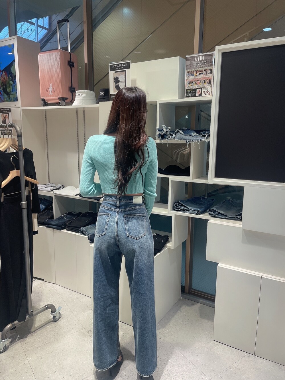 グリーン系のカーディガン/ボレロ、ブルー系のデニムパンツ、ブラック系のパンプスを着用したレディースの冬コーディネートの3枚目の写真