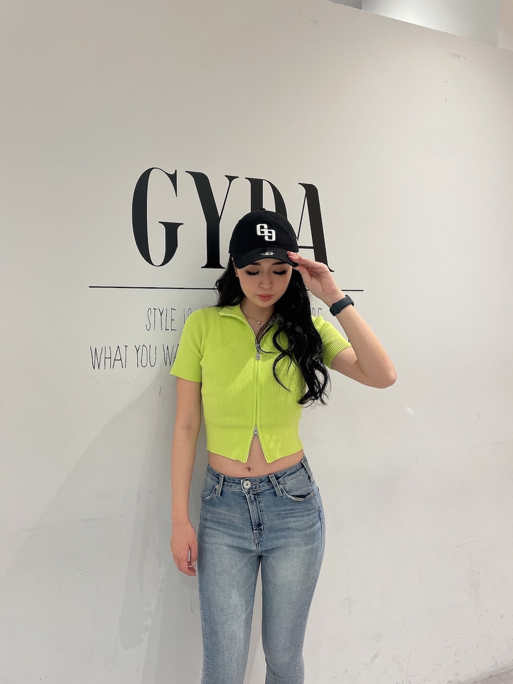 グリーン系のニット/セーター、ブルー系のデニムパンツ、ホワイト系のパンプスを着用したレディースの春コーディネートの4枚目の写真