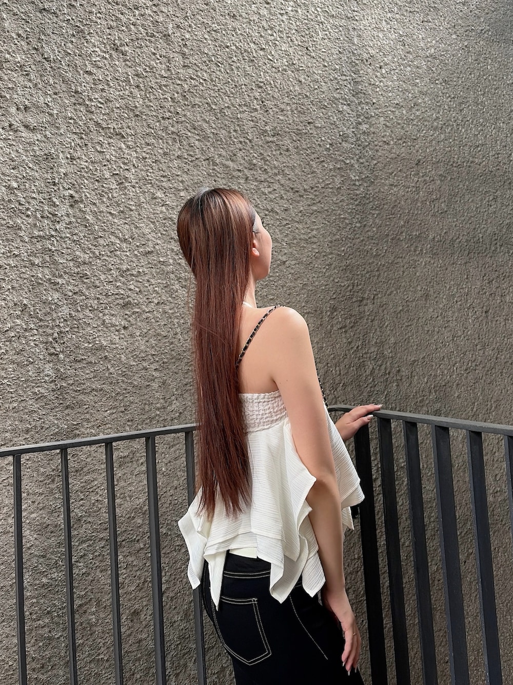 ホワイト系のキャミソール、ブラック系のデニムパンツ、ブラック系のサンダルを着用したレディースの夏コーディネートの5枚目の写真