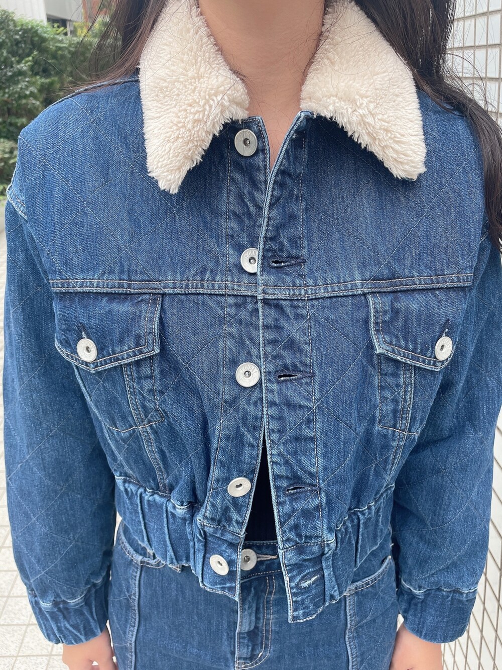 ブルー系のデニムジャケット、ブルー系のデニムスカート、ブラック系のニット/セーターを着用したレディースの秋コーディネートの5枚目の写真