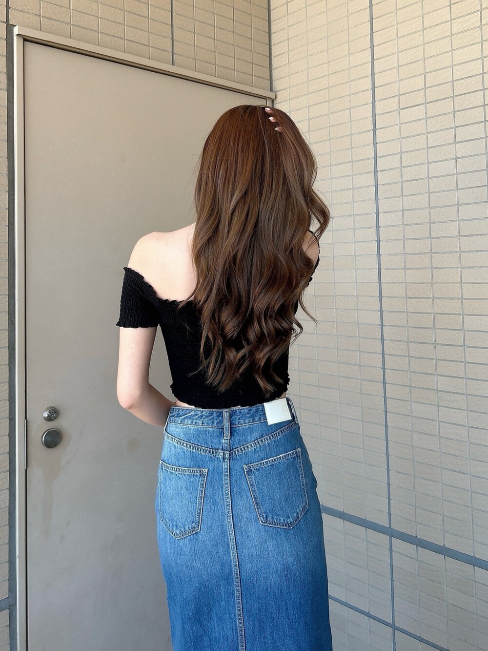 ブラック系のサンダル、ブルー系のデニムスカート、ブラック系のTシャツ/カットソーを着用したレディースの夏コーディネートの6枚目の写真