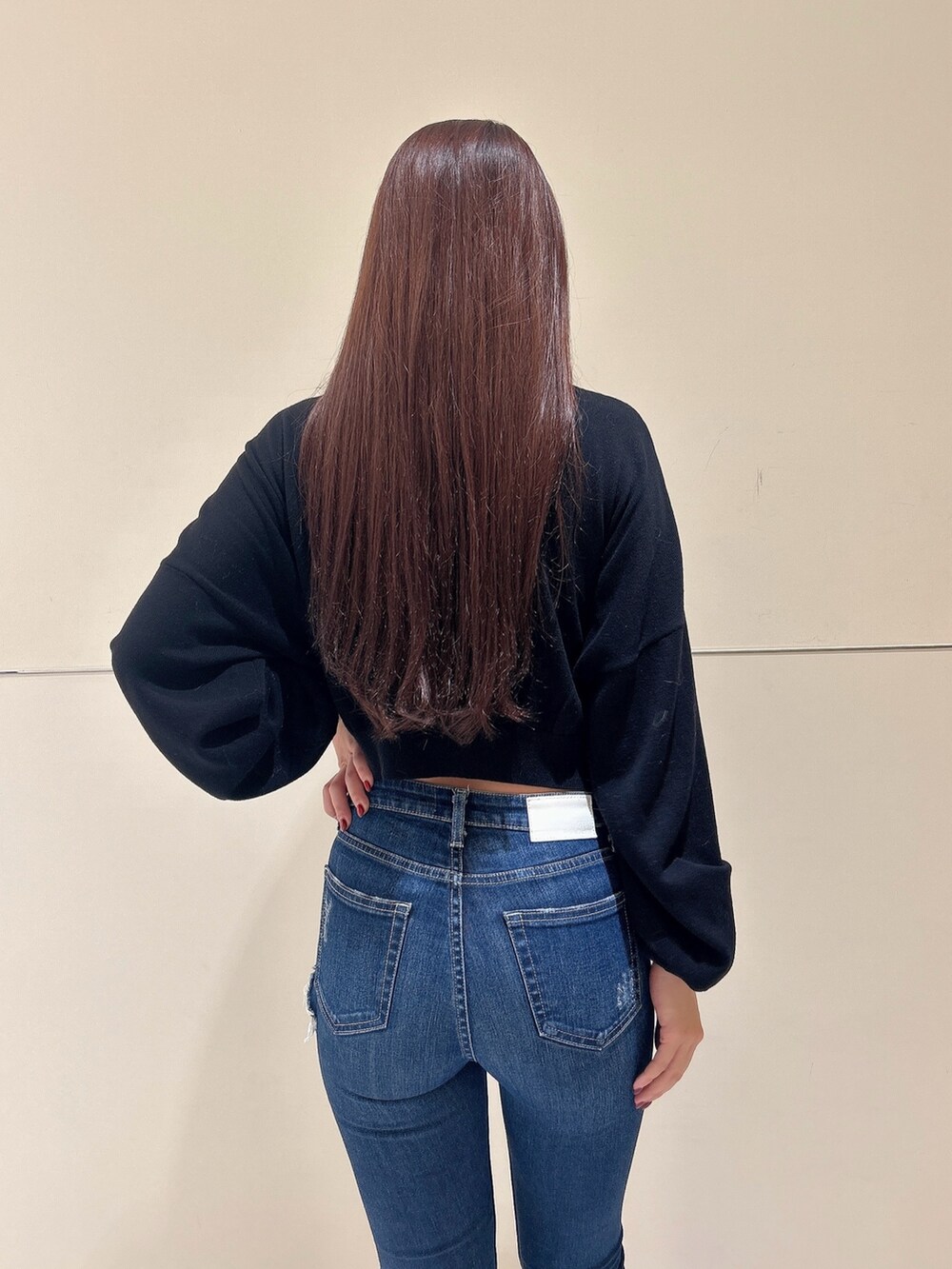 ブラック系のニット/セーター、ブラック系のブーツ、ブルー系のデニムパンツを着用したレディースの秋コーディネートの6枚目の写真