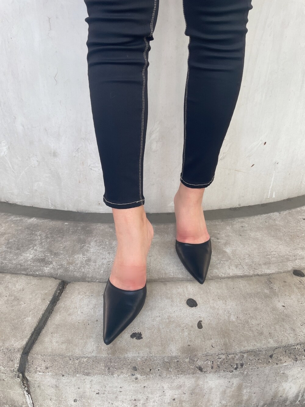 ブラック系のタンクトップ、ブルー系のデニムパンツ、ブラック系のパンプスを着用したレディースの夏コーディネートの7枚目の写真