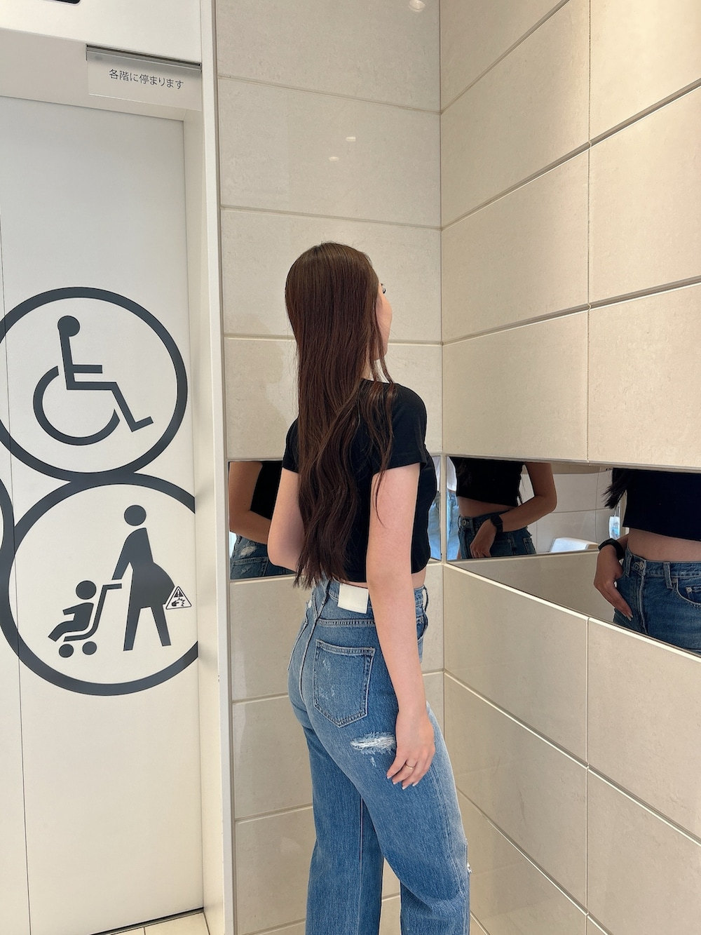 ブラック系のTシャツ/カットソー、ブルー系のデニムパンツ、ブラック系のハンドバッグを着用したレディースの春コーディネートの5枚目の写真