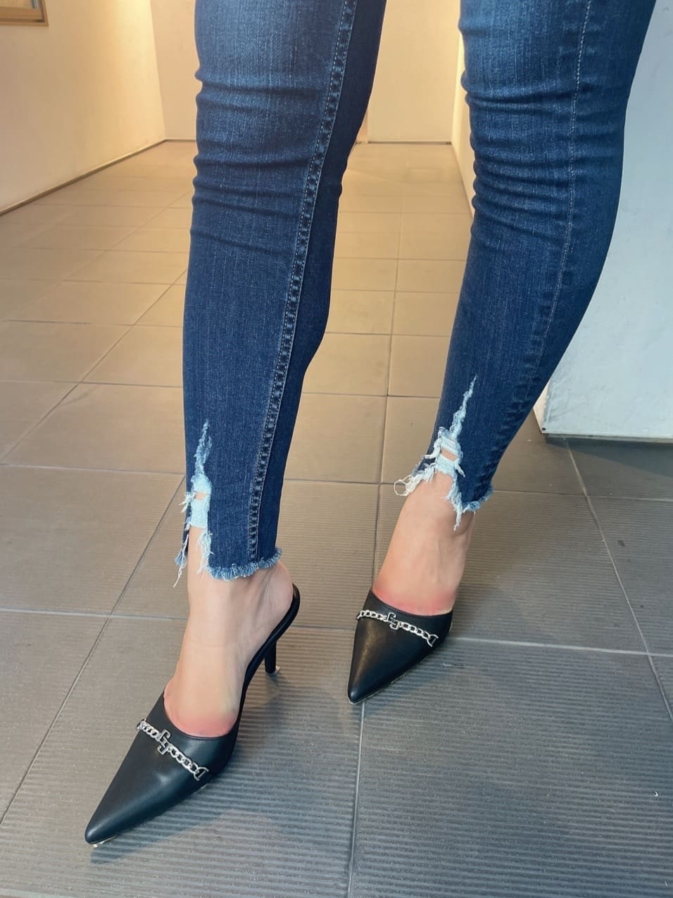ブラック系のパンプス、ブルー系のデニムパンツ、ブルー系のデニムパンツを着用したレディースの秋コーディネートの7枚目の写真