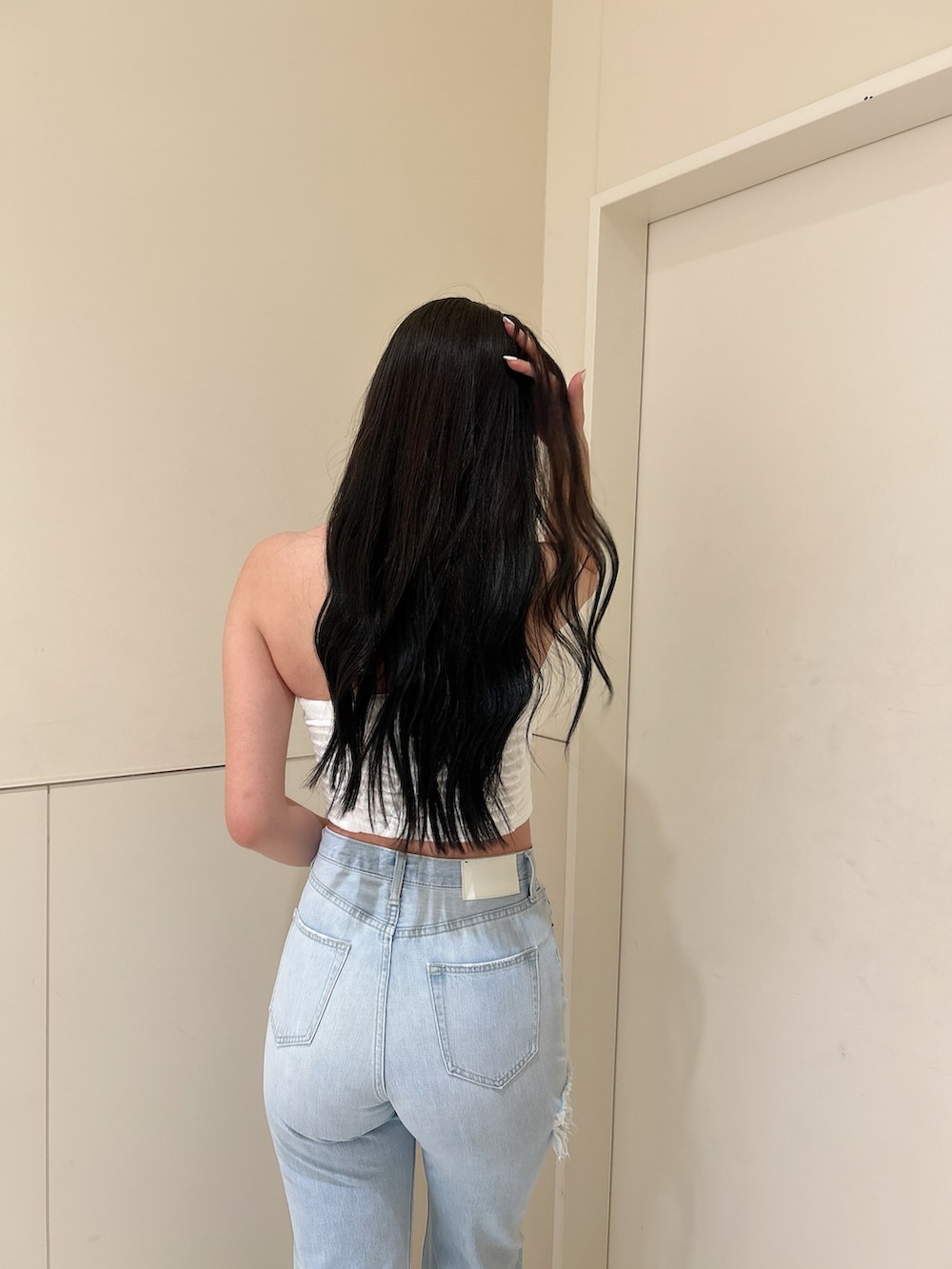 ホワイト系のパーカー、ブルー系のデニムパンツ、ホワイト系のチューブトップを着用したレディースの春コーディネートの6枚目の写真